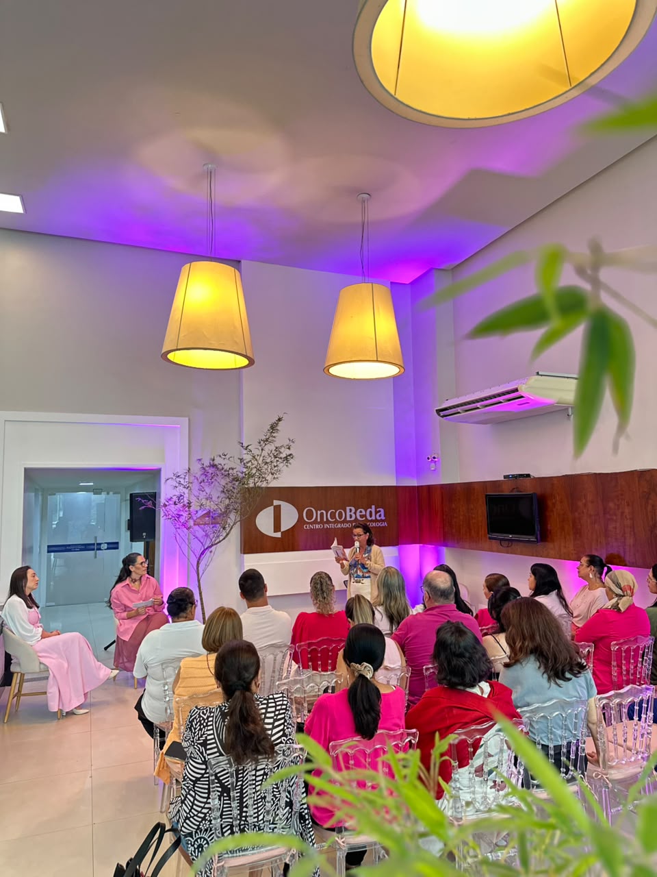 Encontro A Esperança É Rosa no OncoBeda, com participantes reunidos durante uma apresentação.